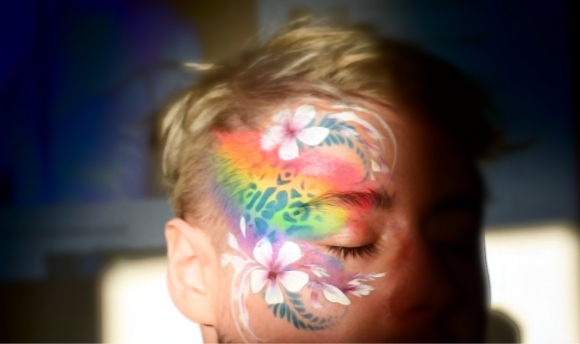 Face painted with rainbow flower design