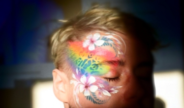Face painted with rainbow flower design