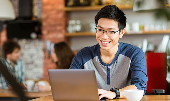 Young guy in cafe on a laptop