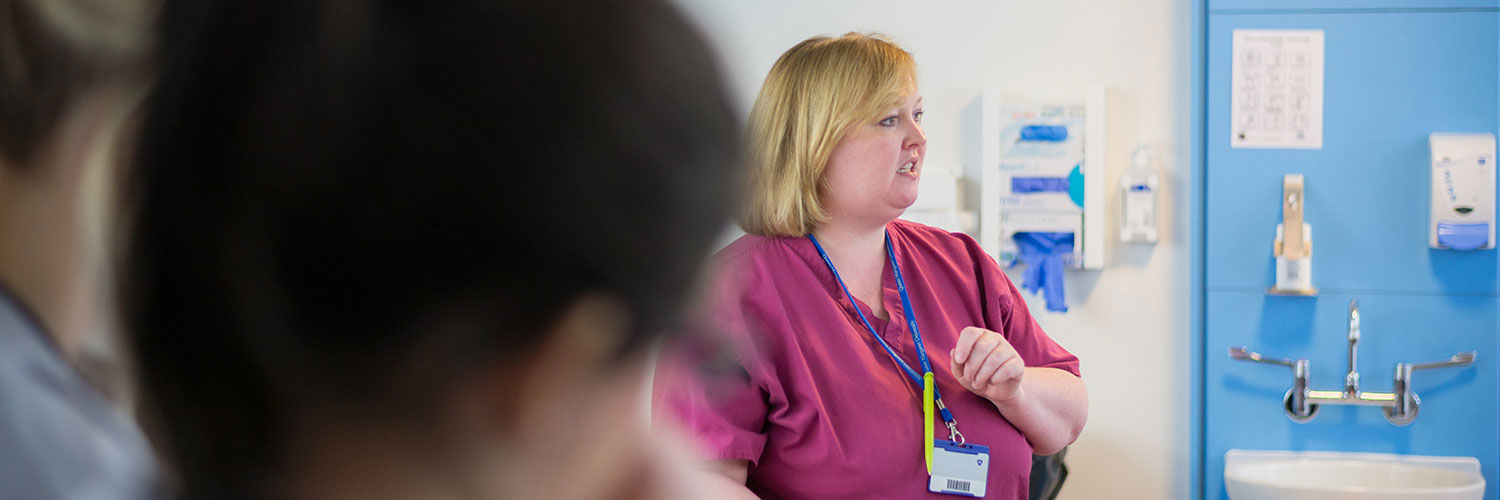 A nurse talking as students watch and listen
