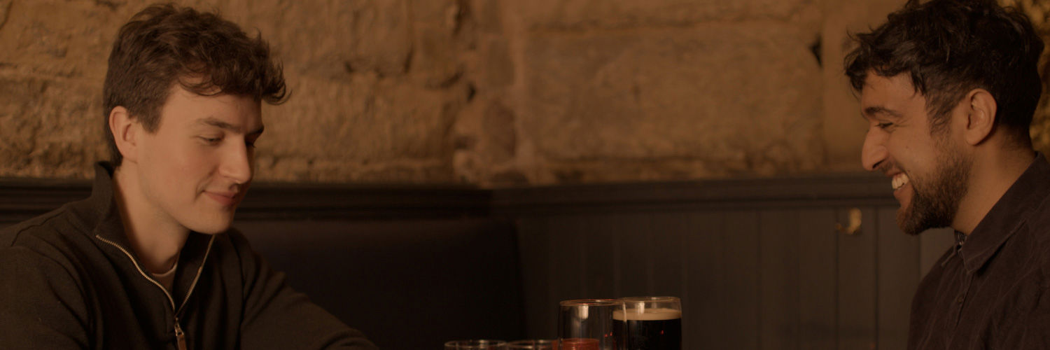Two men enjoying a beer in a dimly lit pub