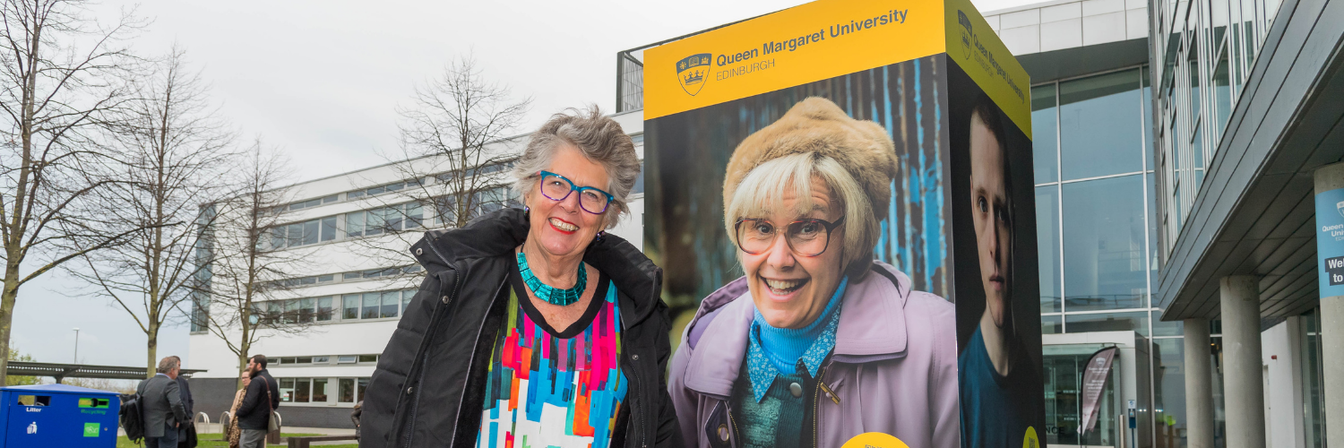 Dame Prue Leith is photographed next to the 50th anniversary drama exhibition stand in University Square which shows the actor and QMU graduate, Jane McCarry.