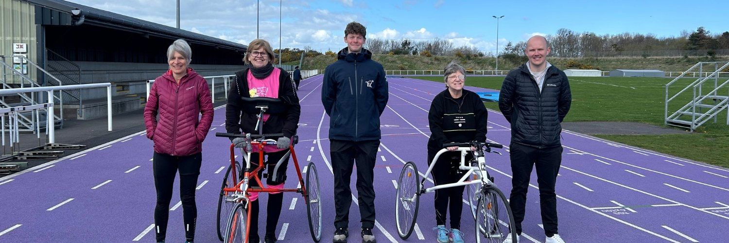 Two frame runners with their trainer and the QMU researchers 