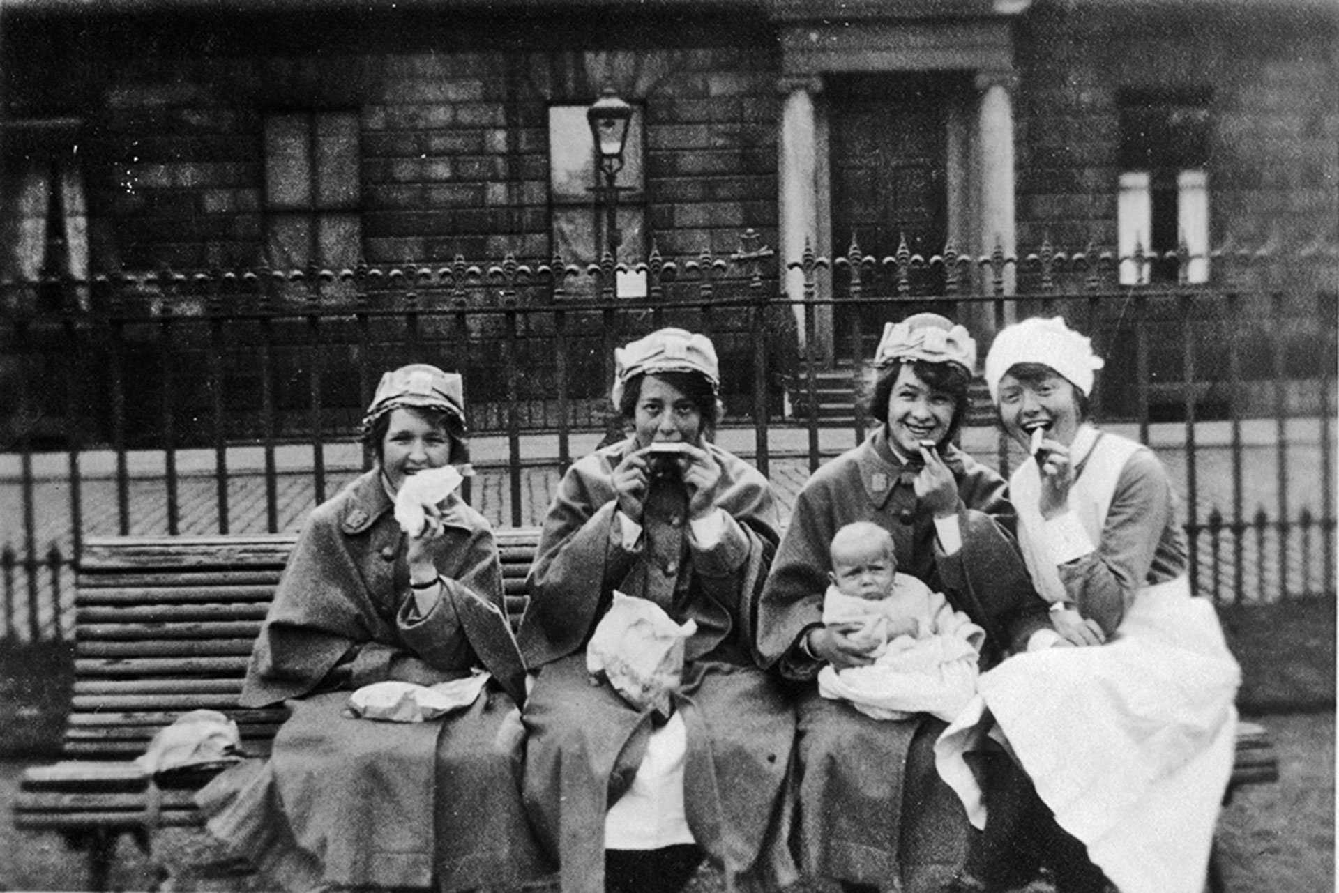 Black and White photo of Princess Louise Nurses enjoying food on a bench in 1922 
