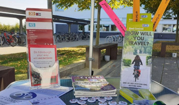 A stall set up on the campus forecourt, the stand is filled with cycling and travel pamphlets and paraphernalia.