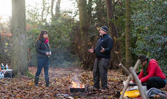 People building a camp fire in the woods