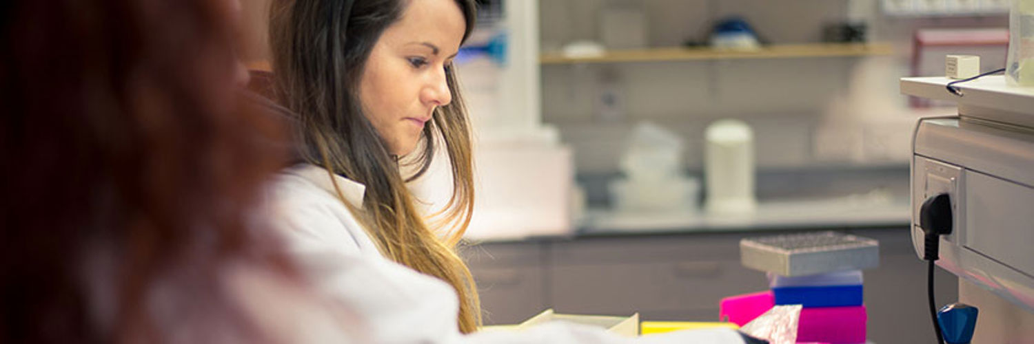 Two students in a laboratory wearing lab coats