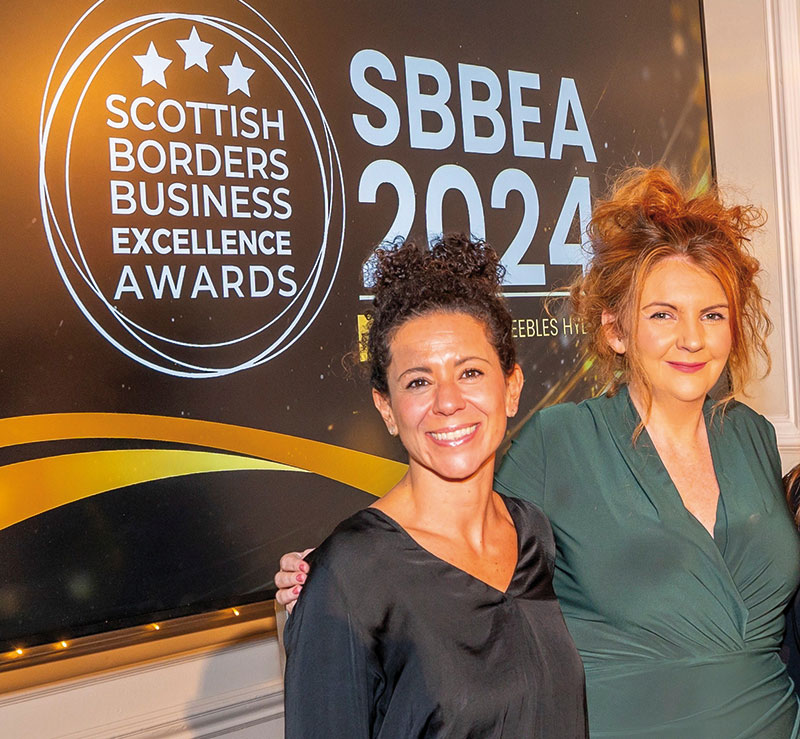 Photo of (L-R) Giorgia Ripanucci with Sian Downes in front of Awards Screen