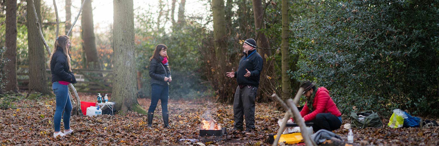 People building a camp fire in the woods