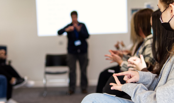 Students practice British Sign Language in a classroom.