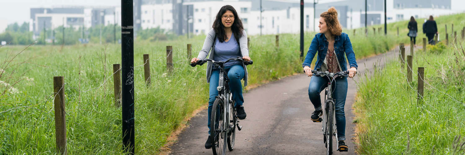 Two students cycling from the QMU campus