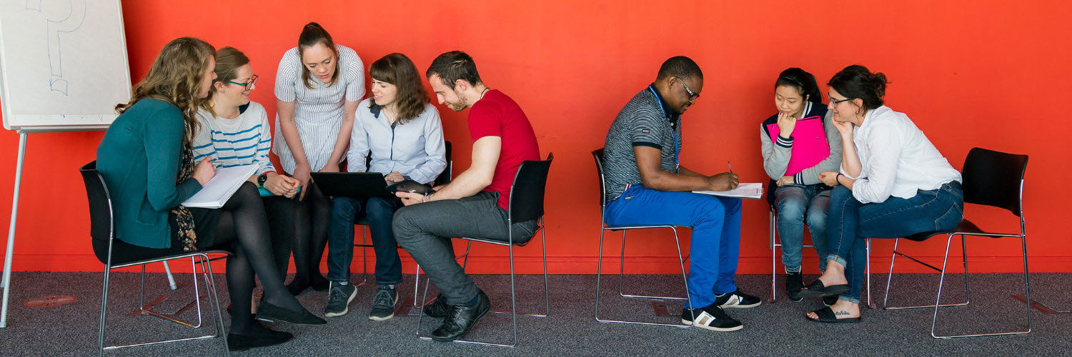 Two groups of QMU students sat in circles working on a group exercise together