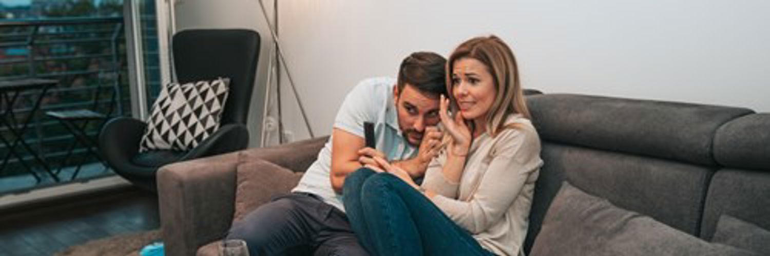 Friends on a sofa scared by horror movie