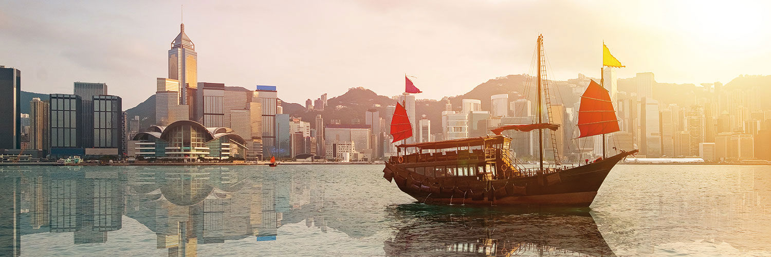 Istock photo of Hong Kong skyline with red sailed Junk in bay