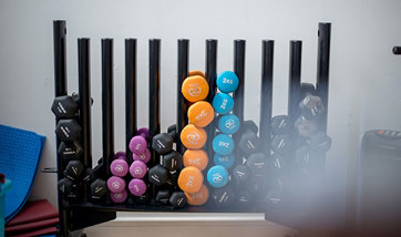 Close up of a large weight rack full of varying weighted dumbbells