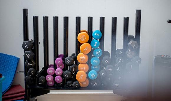 Close up of a large weight rack full of varying weighted dumbbells
