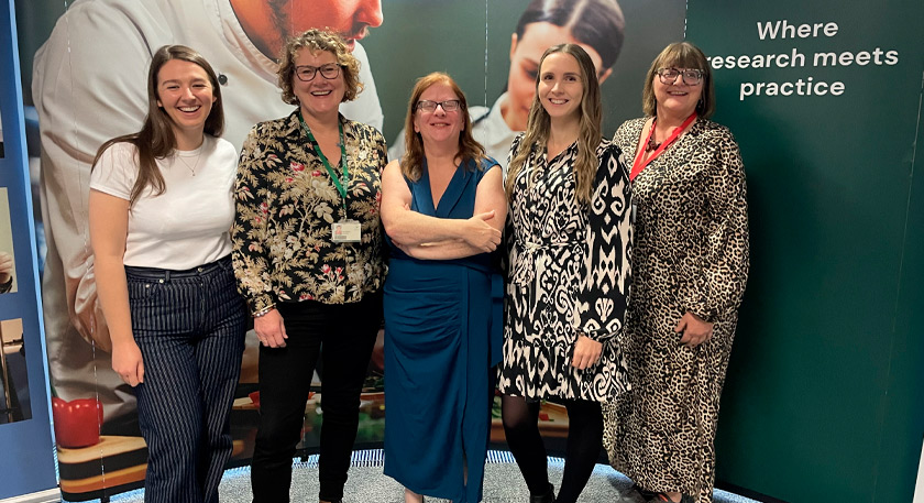 A group of five people smiling at the camera