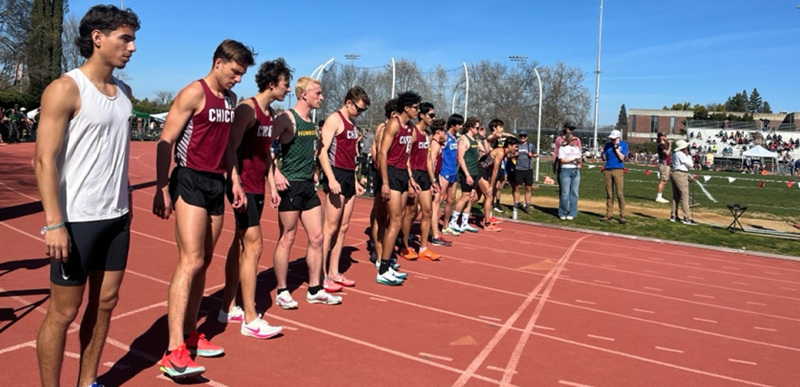 A row of runners lined up at the start of a racetrack