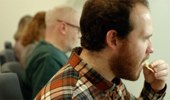 A group of people taste testing crisps.