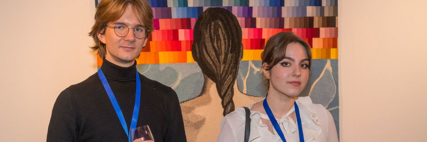 Two students standing in front of some artwork at Dovecot studios