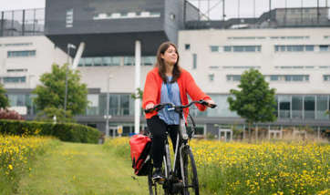 Student cycling on campus grounds