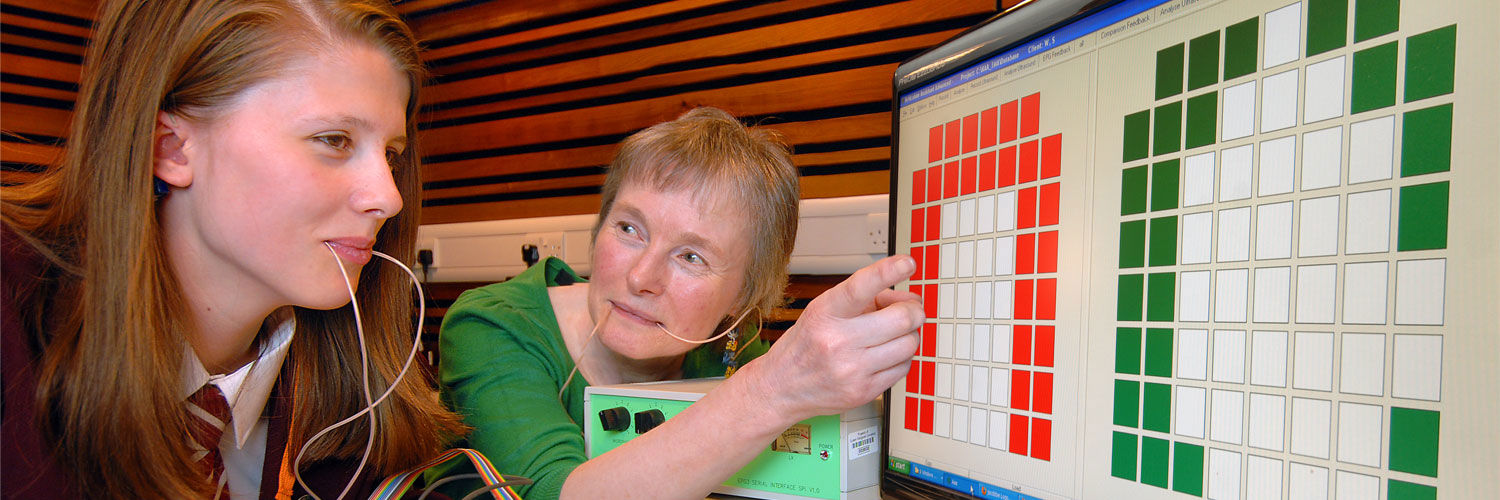 A student & Lecturer with probes in their mouths looking at a screen covered in coloured squares