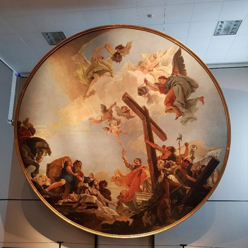 A piece of Renaissance-style artwork hangs in a circular frame.