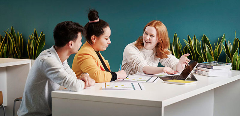 A group of people sat at a table, working on a project together.