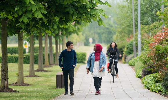 QMU students walking and cycling on campus grounds