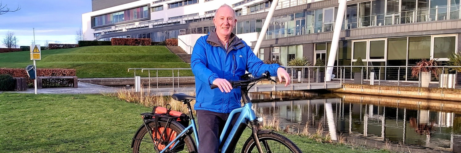 Professor Jim Scobbie standing with his bike outside the Queen Margaret Campus