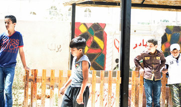 Four children standing idly outside in the sun
