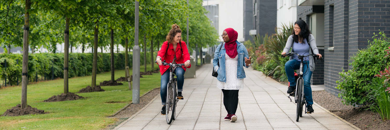 Friends cycling on QMU campus grounds
