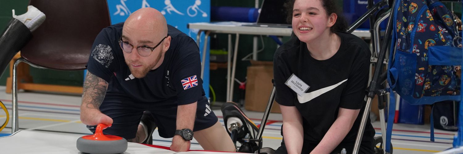 close up of man and young woman kneeling down curling on the ice