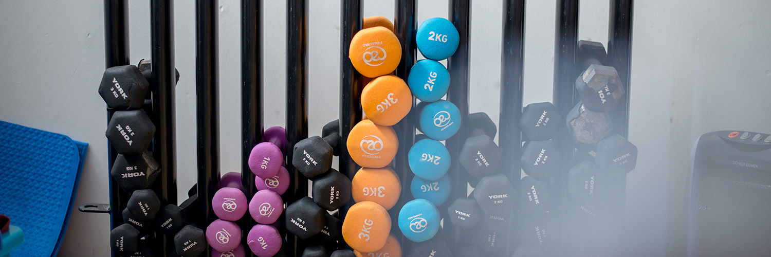 Close up of a large weight rack full of varying weighted dumbbells
