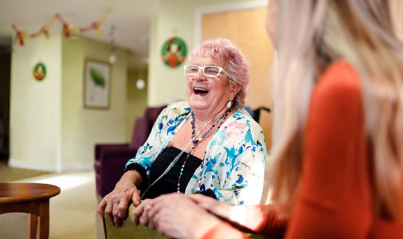 Elderly woman in care home talking to staff
