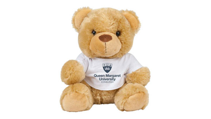A small teddy bear wearing a QMU branded t-shirt