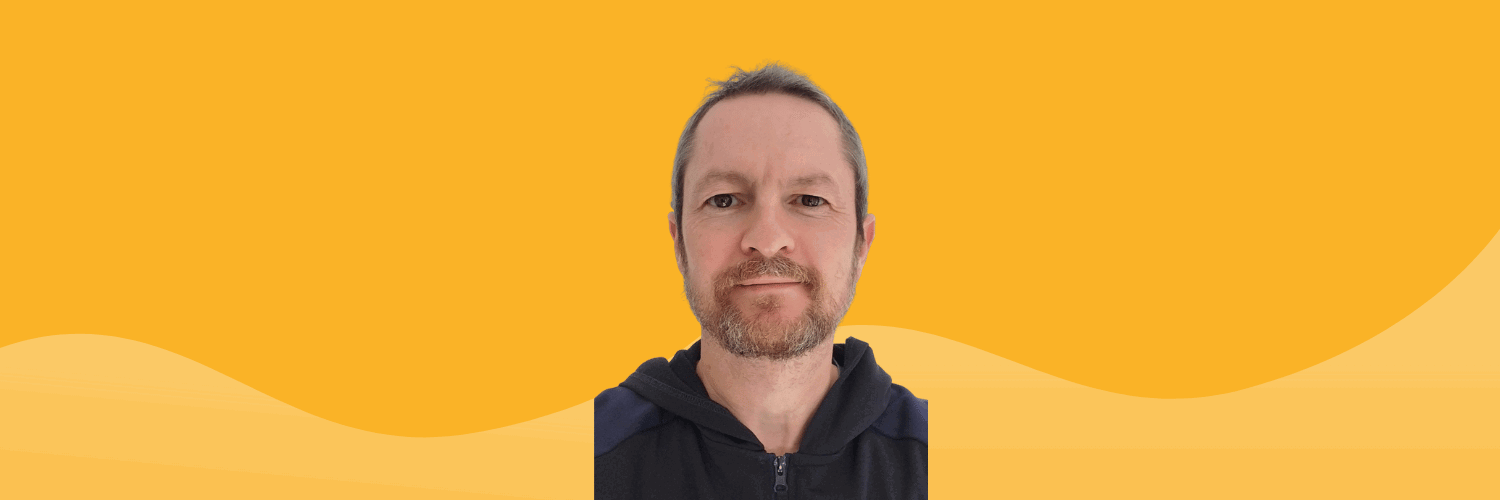 A headshot of a QMU graduate with a bright yellow background