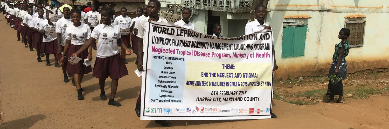 A group of children walking down the street with a large banner