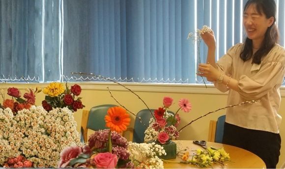 QMU student Ryoko holding and arranging flowers