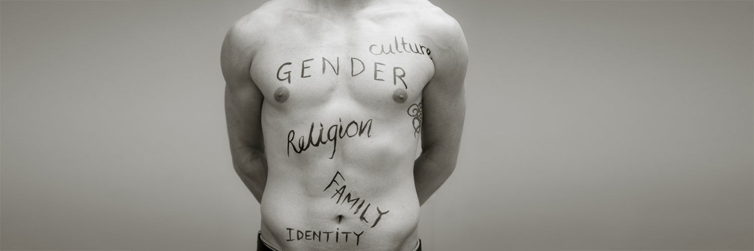A bare torso covered in written words "Gender", "Culture", "Religion", "Family" and "Identity"