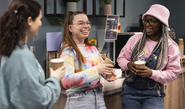Three female students drinking coffee in the Nook