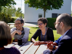 Image of staff conversing outside QMU