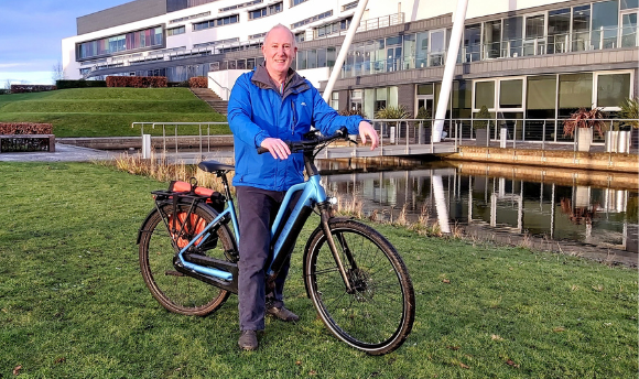Professor Jim Scobbie standing with his bike outside the Queen Margaret Campus
