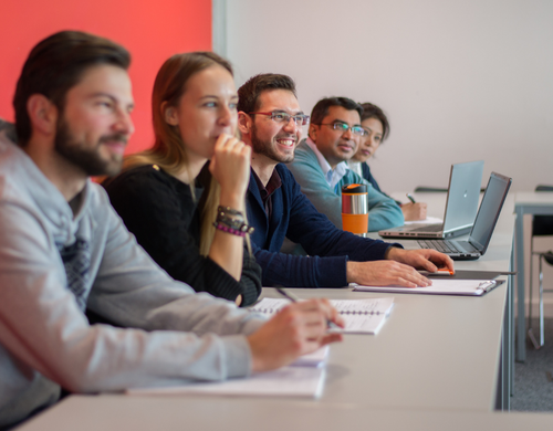 QMu students taking seminar notes on notepads and laptops