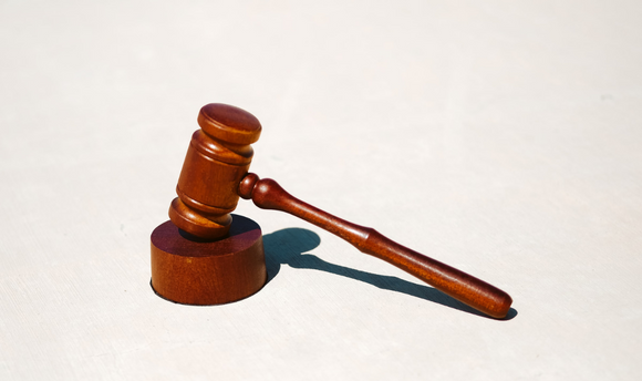An image of a gavel and block, as used in the legal system.