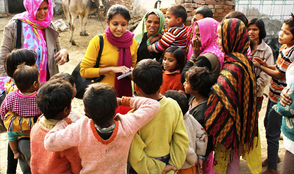 A couple of aid workers surrounded by a group of children