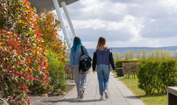 Two people walking together on the QMU campus