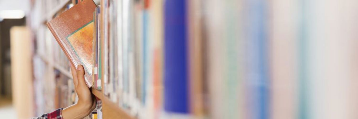 Person removing book from bookshelf