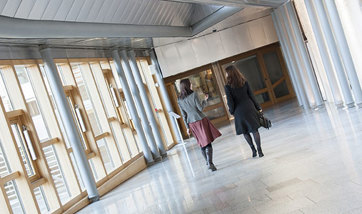 Two women walking down a corridor