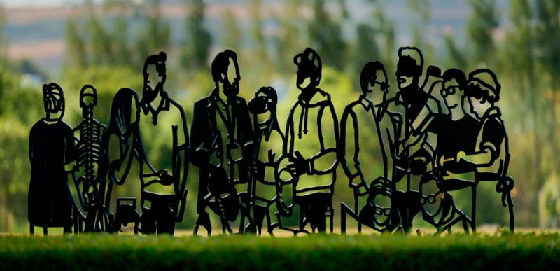 A steel sculpture made of linocut-style figures of different people